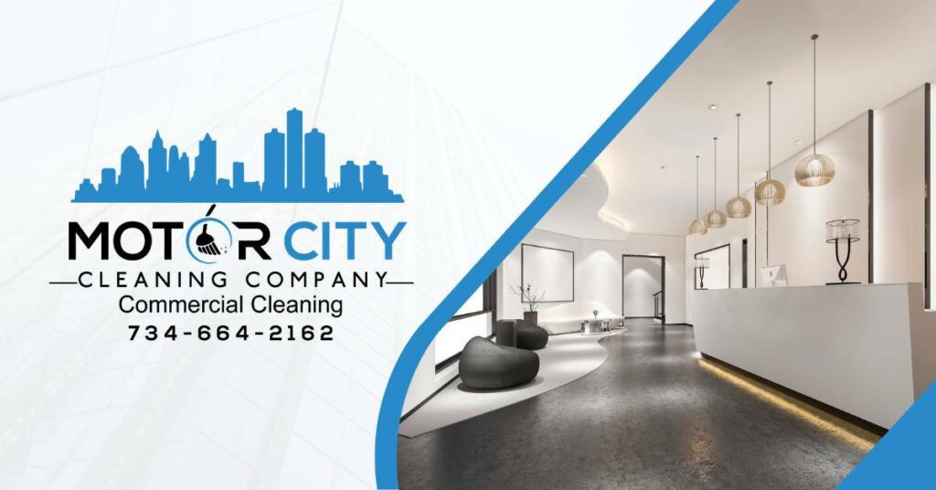 A Clean Luxurious Reception Desk Area With Lights Hanging From The Ceiling and Two Black Modern Seats and a White Couch Across From the Reception Desk | Commercial Cleaning Services | Motor City Cleaning Company